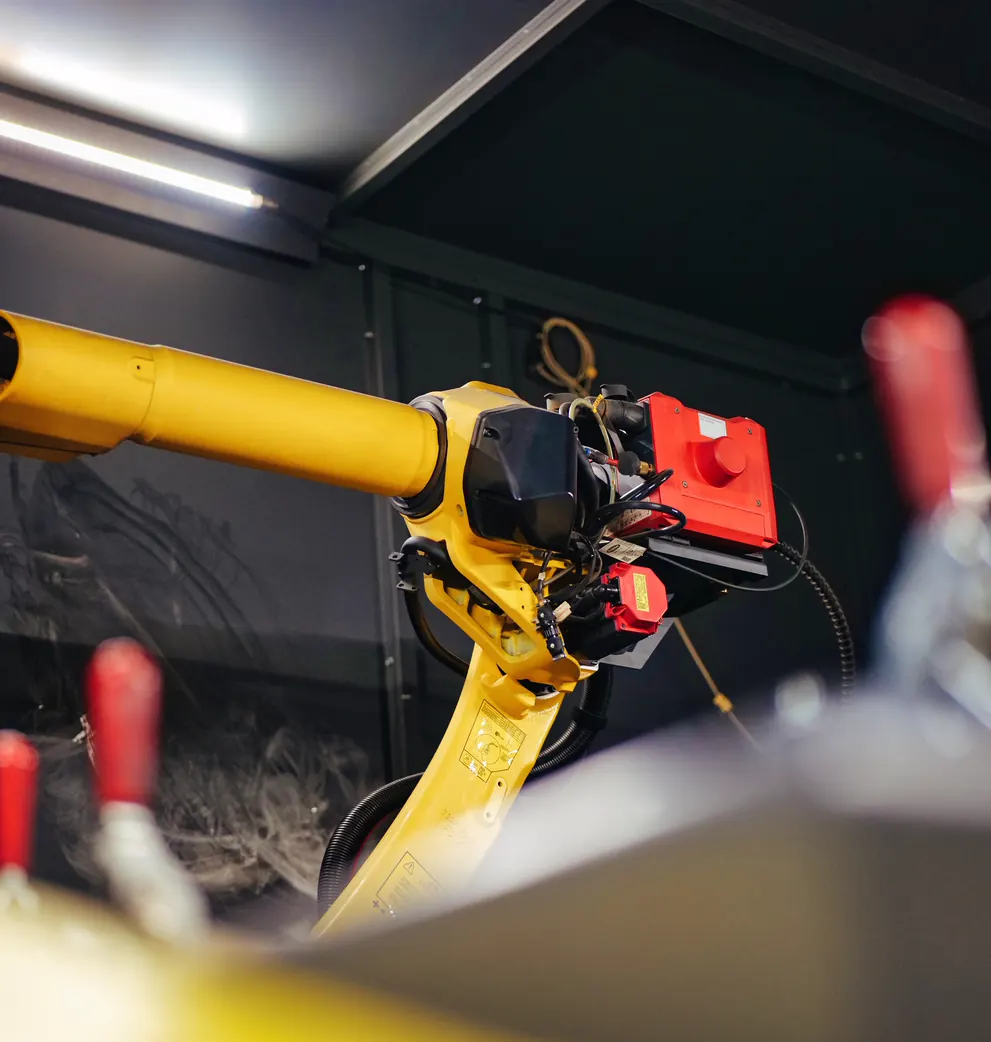 Sárga hegesztőrobot a hegesztőcellában