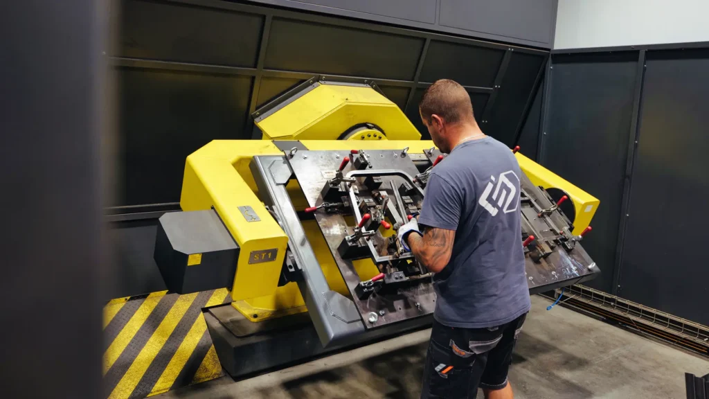 Dolgozó egy robotcella munkadarabja mellett